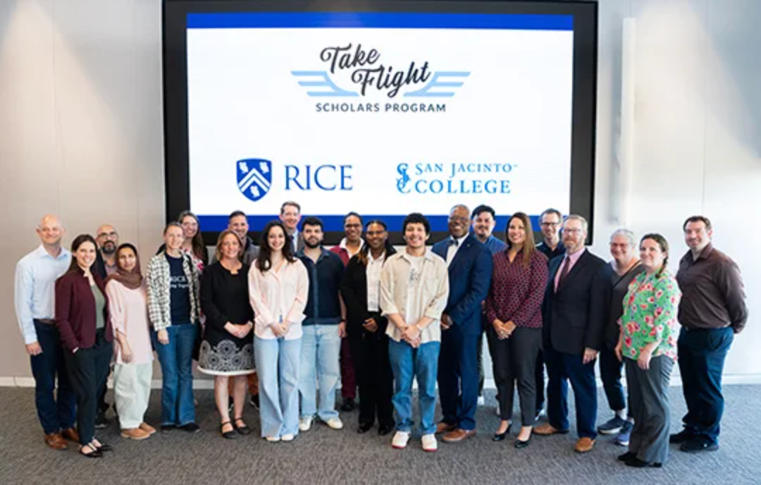Take Flight Scholars students and representatives from Rice University and San Jacinto College pose together beneath a screen displaying the program and college logos.