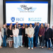 Take Flight Scholars students and representatives from Rice University and San Jacinto College pose together beneath a screen displaying the program and college logos.